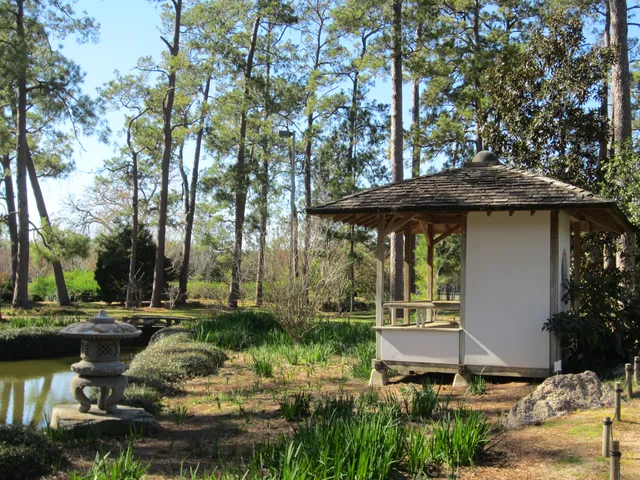 A stone lantern and pavilion in the same Japanese Garden at Hermann Park.